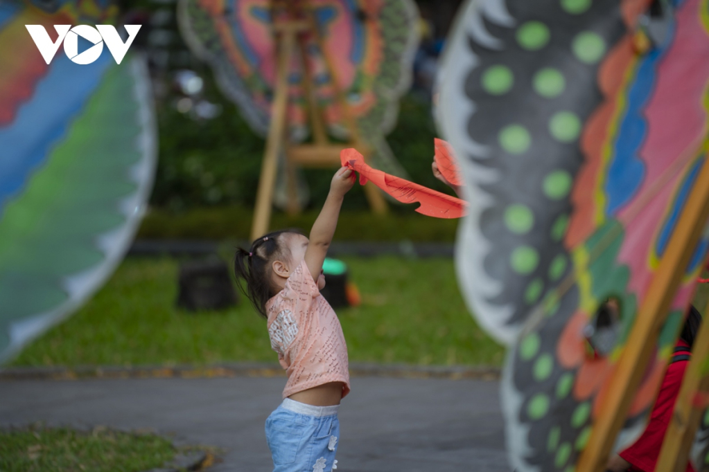 Một em nhỏ đang tò mò tìm hiểu về cánh diều.