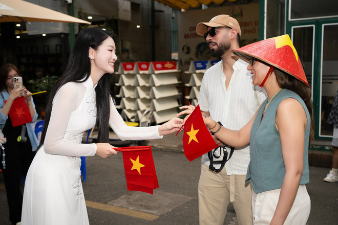 Du khách quốc tế được tặng cờ Tổ quốc tại Đường sách Thành phố Hồ Chí Minh. (Ảnh: CTV/Vietnam+)