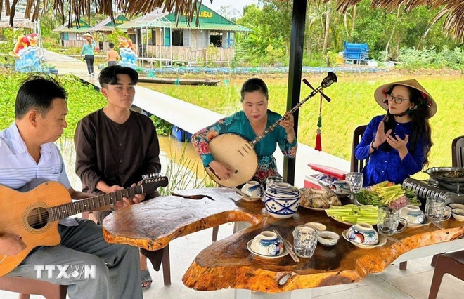 Biểu diễn đờn ca tài tử ở điểm du lịch sinh thái nông nghiệp Cánh Đồng Cậu Ba. (Ảnh: TTXVN phát)
