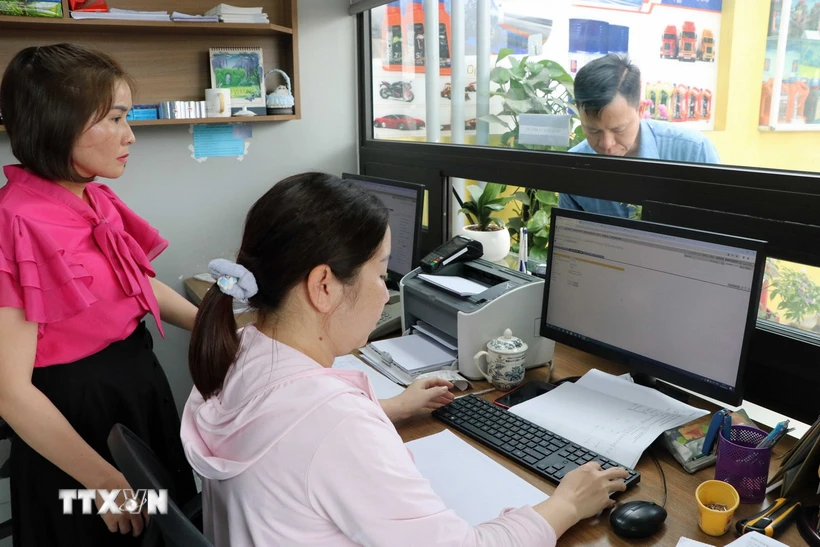 Hoạt động xuất hóa đơn điện tử tại cửa hàng. (Ảnh: Hoàng Ngọc/TTXVN)