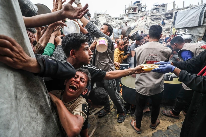 Người dân Palestine chờ được phát thực phẩm cứu trợ tại Gaza. (Ảnh: THX/TTXVN)