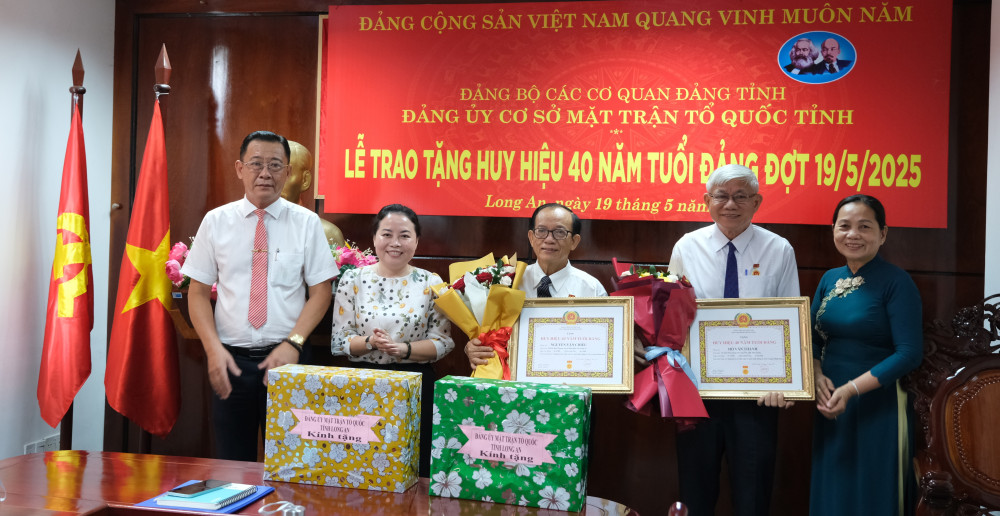 Các đại biểu chụp ảnh lưu niệm với 2 đảng viên được trao Huy hiệu Đảng