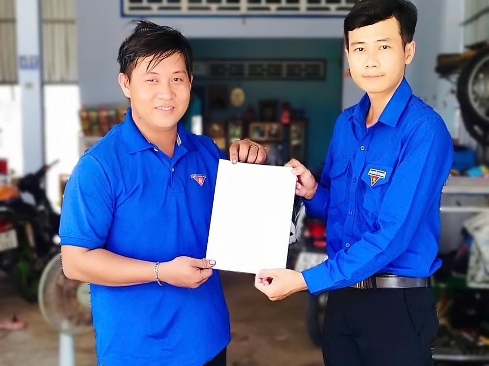 Phó Bí thư Đoàn xã Vĩnh Bình, huyện Vĩnh Hưng - Bùi Đức Tân (bên trái) trao quyết định mô hình kinh tế