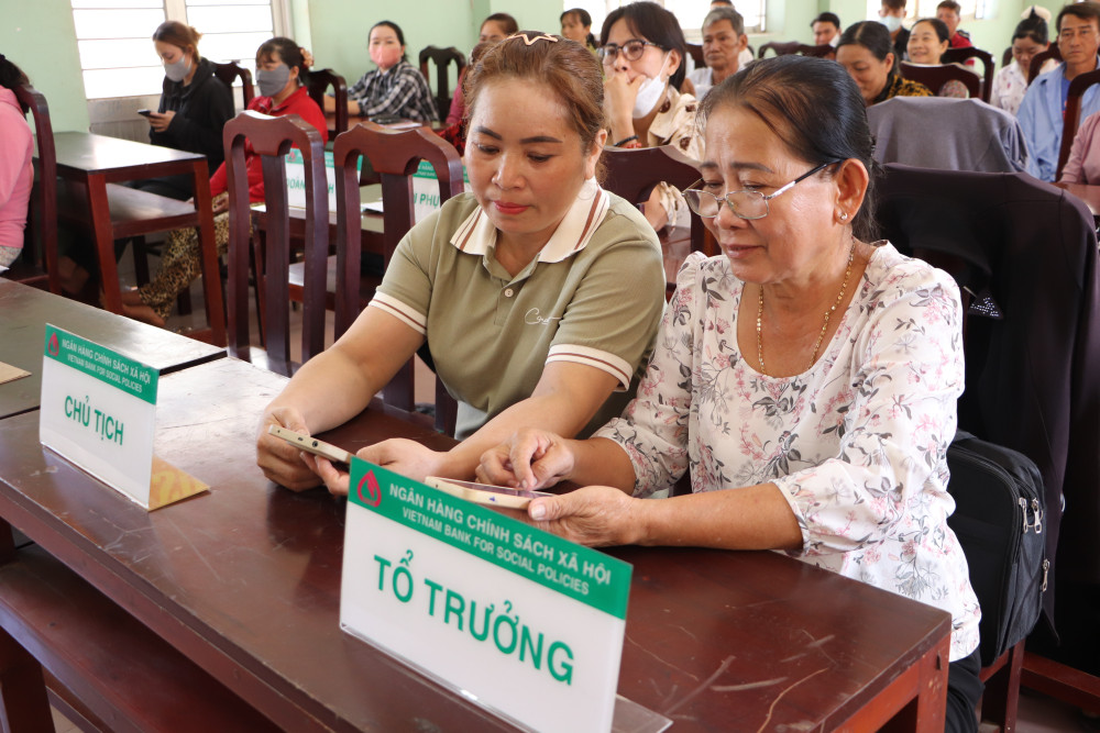 Bà Võ Thị Huệ – Tổ trưởng Tổ TK&VV Hội Liên hiệp Phụ nữ (LHPN) xã Thủy Đông, huyện Thạnh Hóa hướng dẫn  thành viên sử dụng ứng dụng VBSP Smart Banking