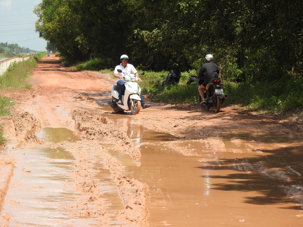 Người dân chạy xe tránh né vũng sâu nguy hiểm