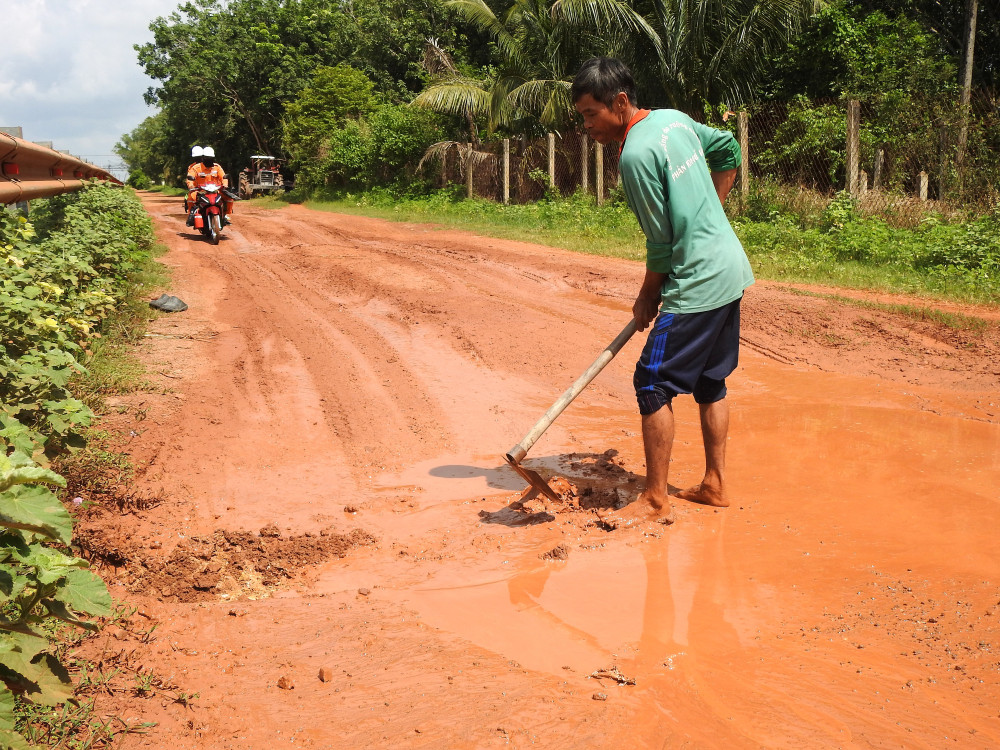 Ông Võ Thanh Dũng khai thông bớt nước tại vũng sâu nhằm hạn chế nguy hiểm cho người dân lưu thông