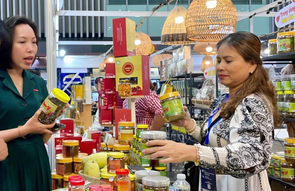 Chị Lan (bìa phải trong ảnh) giới thiệu các sản phẩm đặc trưng của địa phương đến du khách