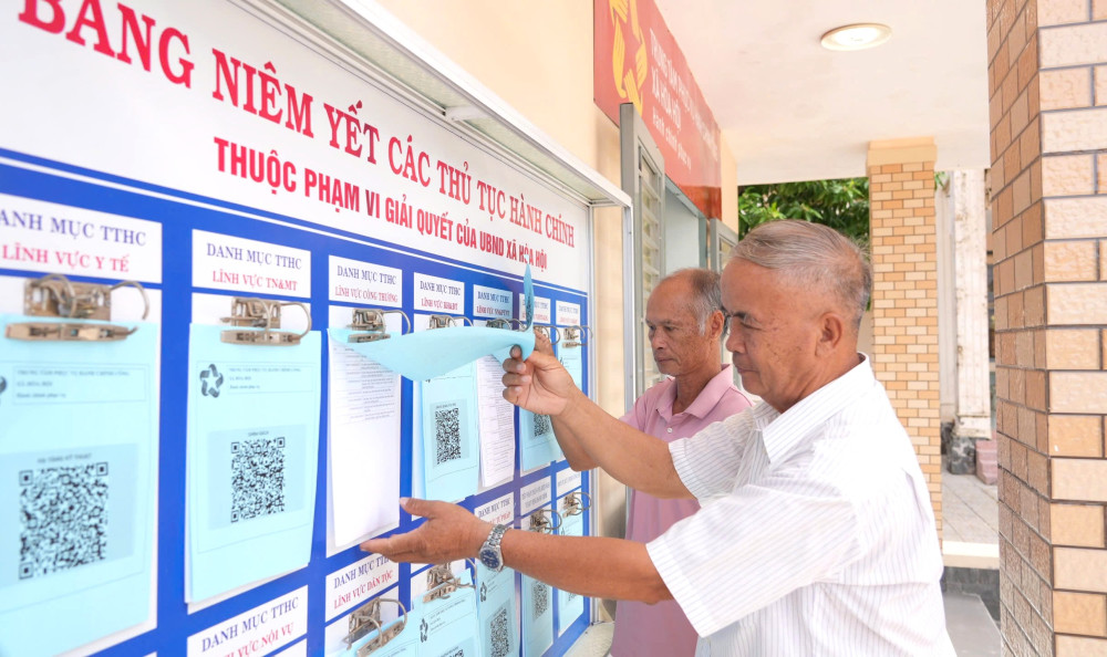 Người dân xem các bộ thủ tục hành chính được niêm yết tại trụ sở UBND xã Hòa Hội