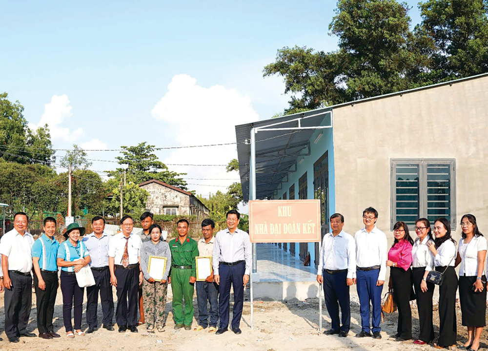 Phó Bí thư Thường trực Tỉnh ủy, Chủ tịch HĐND tỉnh Nguyễn Mạnh Hùng (người đứng cạnh bảng Khu nhà Đại đoàn kết, bên trái) và Ủy viên Ban Thường vụ Tỉnh ủy, Trưởng ban Tổ chức Tỉnh ủy Võ Đức Trong (người đứng cạnh bảng Khu nhà Đại đoàn kết, bên phải) trao nhà cho người dân tại Khu nhà Đại đoàn kết tập trung, phường Hòa Thành  (Ảnh: ĐĂNG ANH)