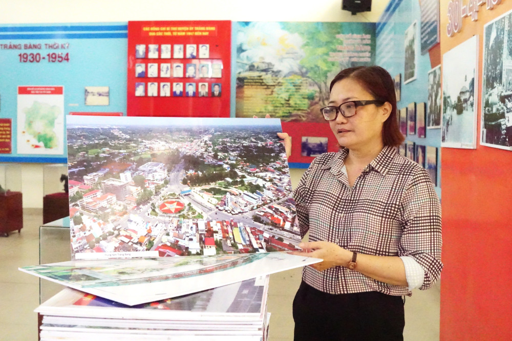 Chị Chung Thị Thu Trang sắp xếp lại một số hình ảnh tư liệu trong Nhà truyền thống phường Trảng Bàng