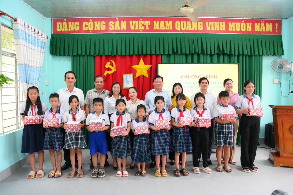 Phó Chủ tịch UBND tỉnh Phạm Tấn Hòa cùng đại diện nhà tài trợ trao học bổng cho học sinh có hoàn cảnh khó khăn