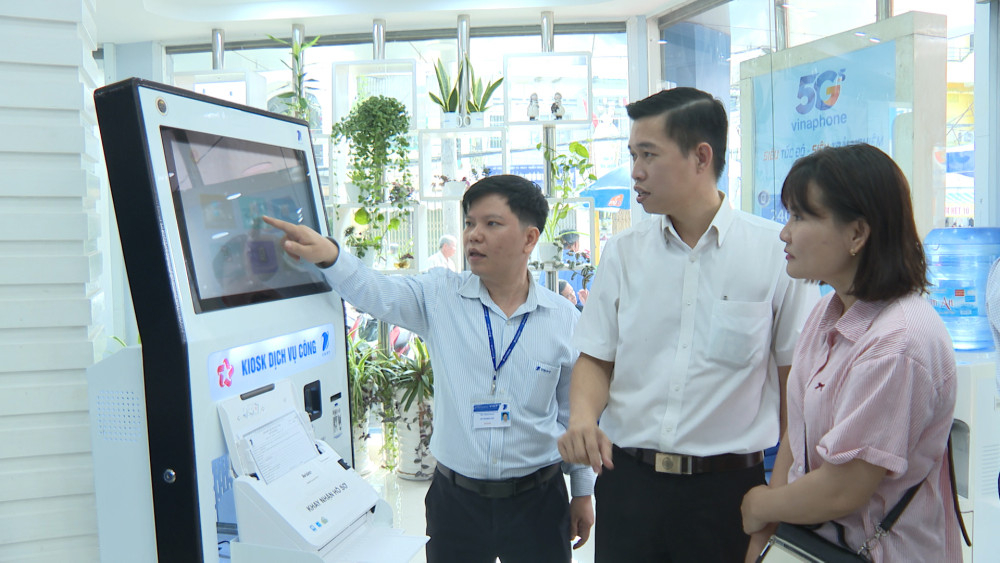 Cán bộ hướng dẫn người dân thao tác trên Kiosk dịch vụ công trực tuyến tại Trung tâm Chăm sóc khách hàng VNPT Tân An