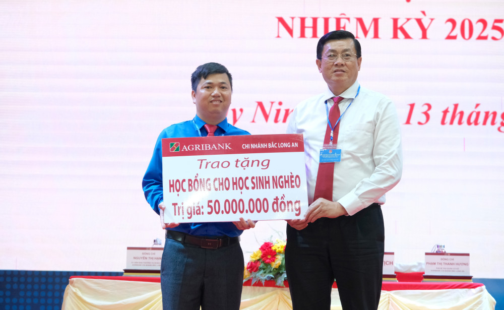 Giám đốc Agribank Chi nhánh Bắc Long An Phan Tấn Luân trao biểu trưng tặng học bổng cho học sinh nghèo cho đại diện lãnh đạo Tỉnh Đoàn 