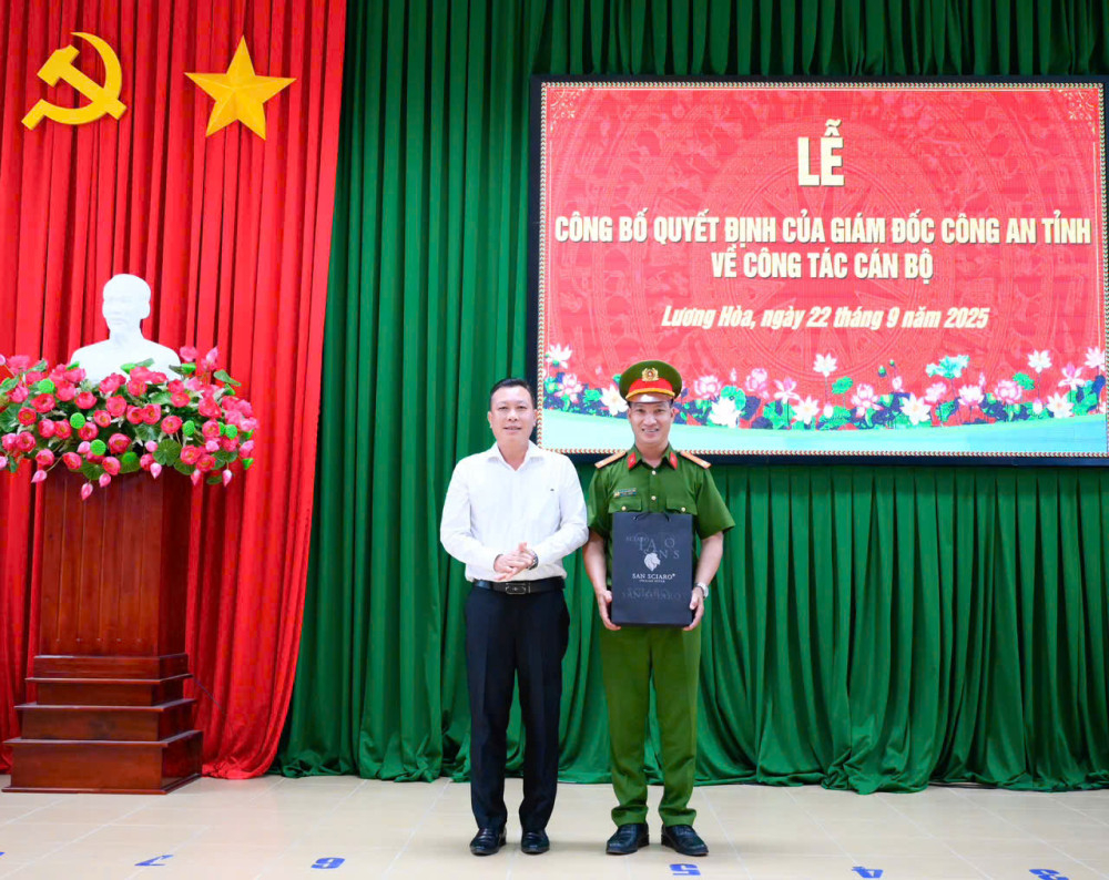Phó Bí thư Đảng ủy, Chủ tịch UBND xã Đặng Cửu Long trao quà lưu niệm cho Trung tá Phạm Tấn Huỳnh Còn