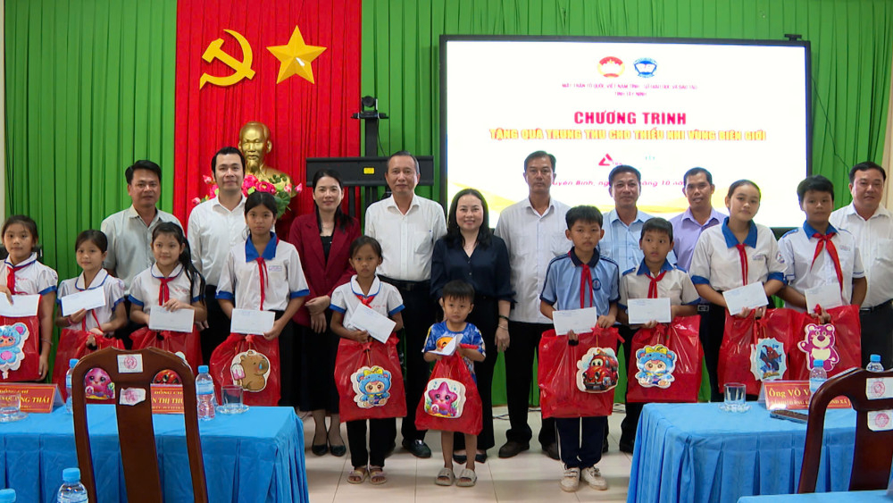 Đại biểu trao quà cho các em thiếu nhi có hoàn cảnh khó khăn