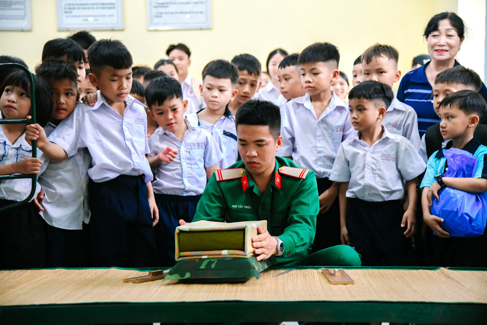 Các em học sinh theo dõi chú bộ đội xếp nội vụ