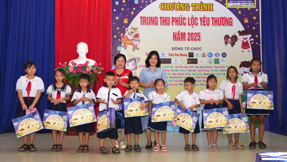 Ủy viên Ban Thường vụ Tỉnh ủy, Trưởng ban Tuyên giáo và Dân vận Tỉnh ủy Nguyễn Thị Xuân Hương trao quà cho thiếu nhi xã Long Chữ
