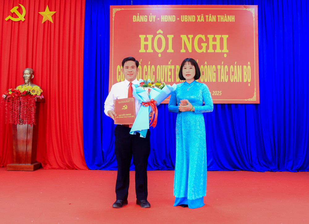 Bí thư Đảng ủy, Chủ tịch HĐND xã Nguyễn Thị Trúc Mai trao quyết định và tặng hoa chúc mừng ông Võ Châu Thông
