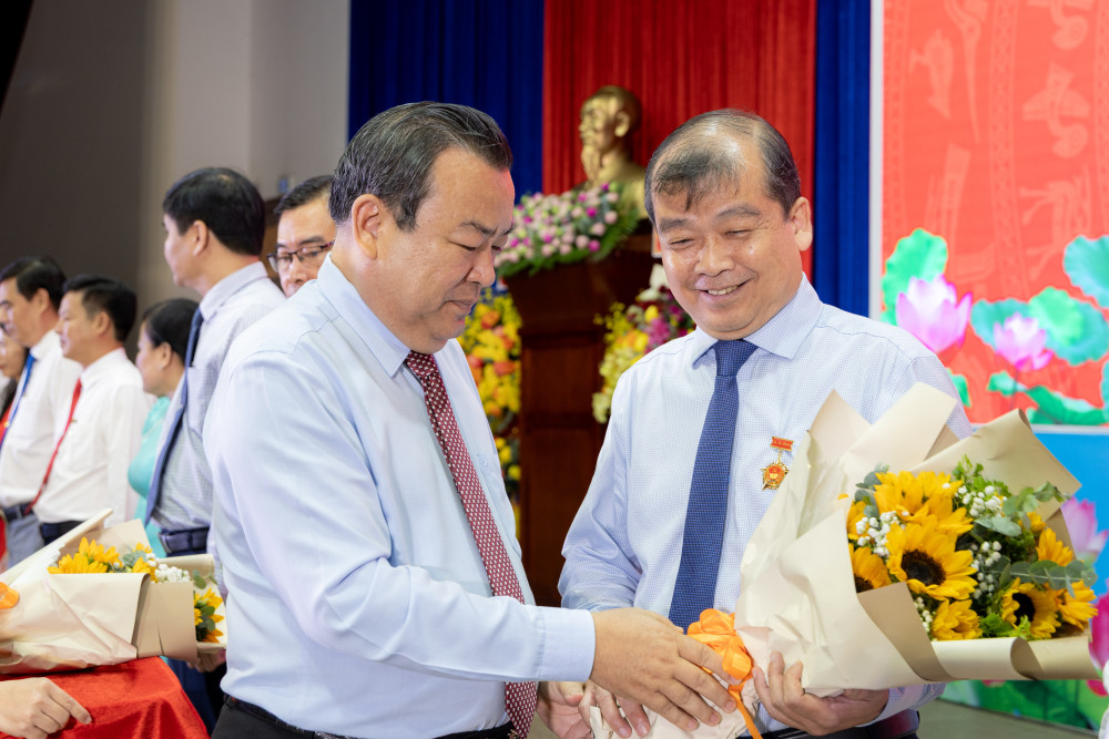 Phó Bí thư Tỉnh ủy, Trưởng đoàn đại biểu Quốc hội tỉnh Phạm Hùng Thái (bên trái) trao kỷ niệm chương và hoa cho Ủy viên Ban Thường vụ Tỉnh ủy, Trưởng ban Tổ chức Tỉnh ủy Võ Đức Trong 