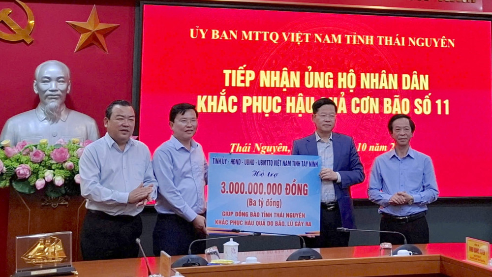 Lãnh đạo tỉnh Tây Ninh (bên trái) trao hỗ trợ cho Chủ tịch UBMTTQ tỉnh Thái Nguyên Đinh Quang Tuyên