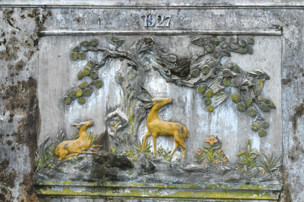 Án ngữ ở lối vào mộ phía bắc là bình phong từ đá ong cao 3m, có đắp nổi hoa văn Mai – Lộc