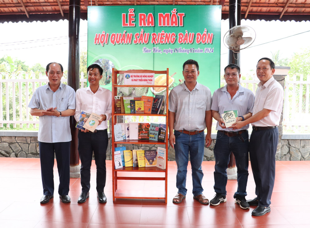 Đại diện Văn phòng Bộ, Trưởng cơ quan đại diện phía Nam, Bộ Nông nghiệp và Phát triển nông thôn (bìa trái) trao tặng sách do Bộ trưởng Nông nghiệp và Phát triển nông thôn (nay là Phó Chủ tịch Quốc hội) Lê Minh Hoan gửi tặng Hội quán sầu riêng Bàu Đồn (Ảnh tư liệu)