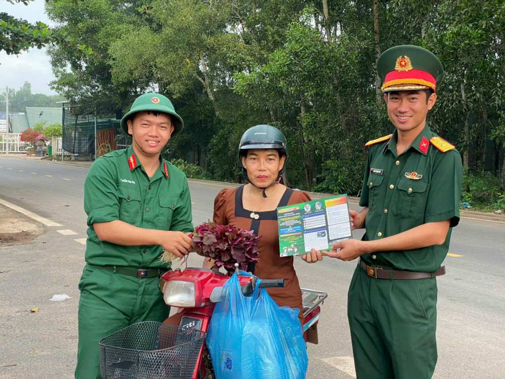 Cán bộ, chiến sĩ Đại đội Bộ binh 6 phát tờ rơi tuyên truyền pháp luật cho người dân