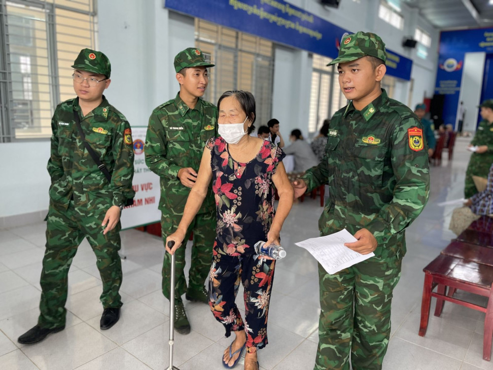 Các chiến sĩ hỗ trợ người dân đến khám bệnh