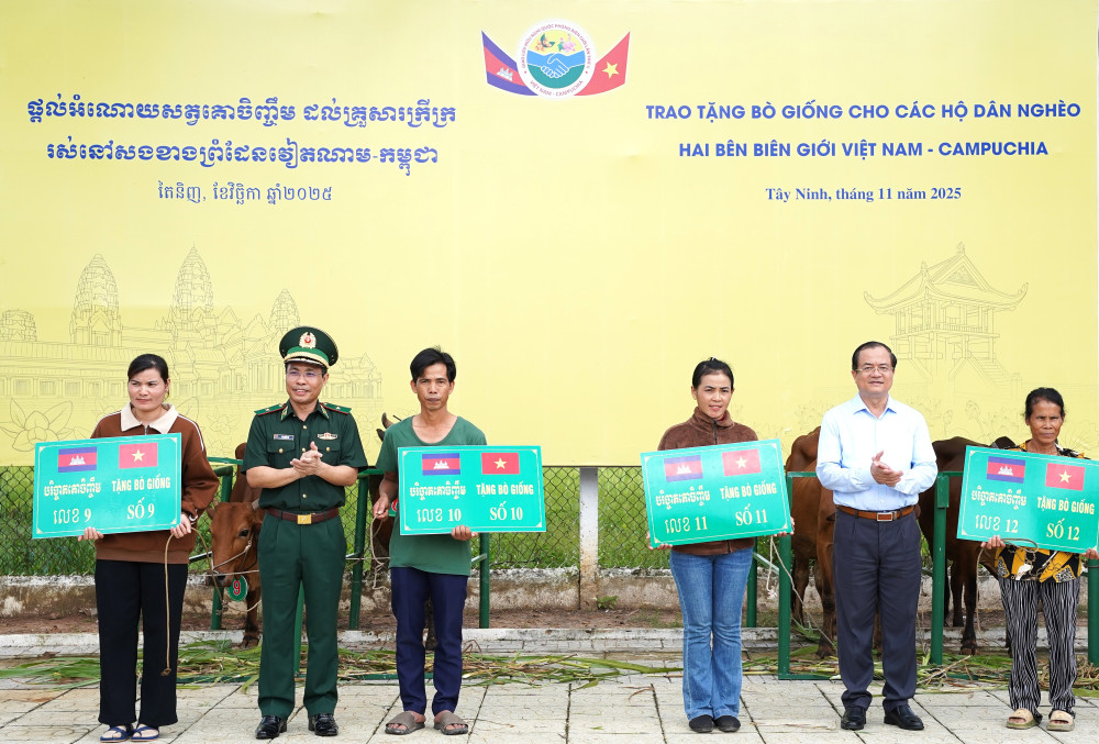 Thiếu tướng Vũ Quốc Ân - Phó Chính ủy BĐBP Việt Nam và Ủy viên Ban Thường vụ Tỉnh ủy, Phó Chủ tịch UBND tỉnh Tây Ninh Nguyễn Hồng Thanh trao bảng tượng trưng tặng bò giống cho các hộ dân