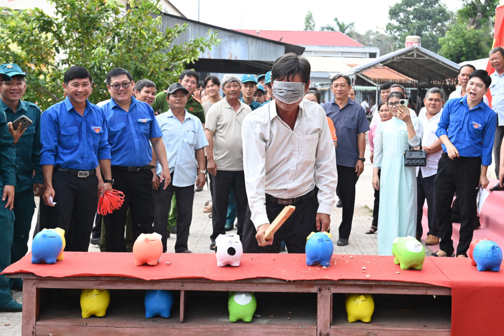 Người dân tham gia trò chơi bịt mắt đập heo đất trúng thưởng