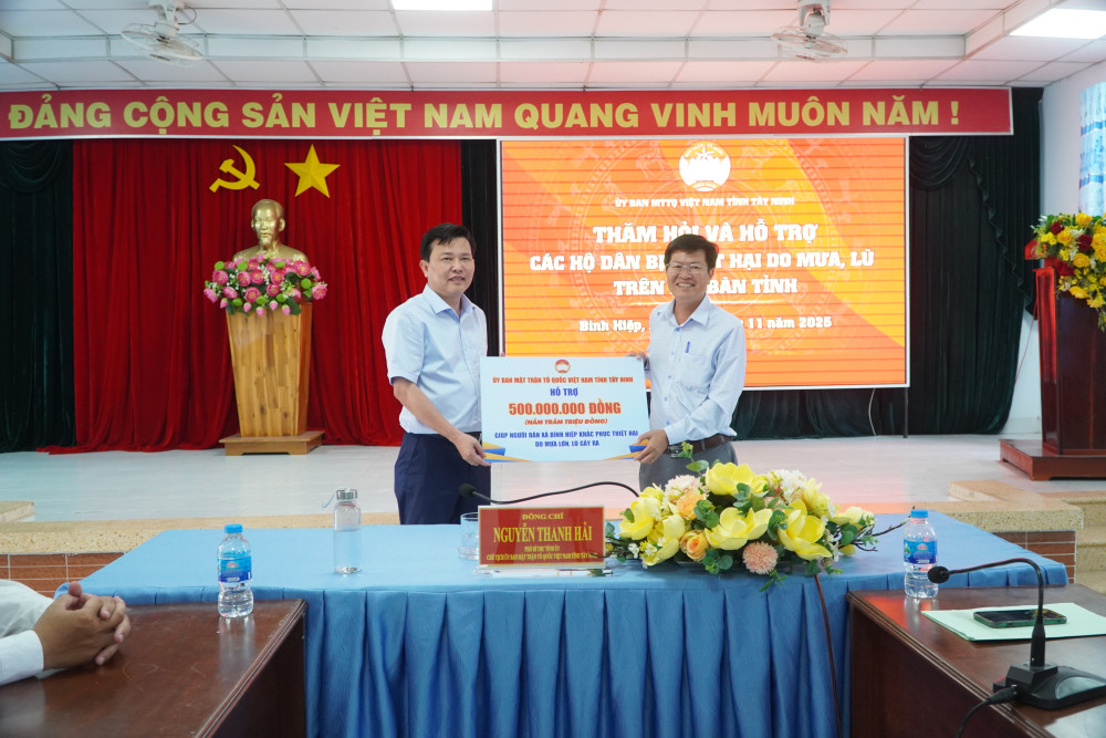 Phó Bí thư Tỉnh ủy, Chủ tịch UBMTTQ Việt Nam tỉnh Nguyễn Thanh Hải trao biểu trưng hỗ trợ 500 triệu đồng giúp người dân xã Bình Hiệp khắc phục thiên tai do mưa lớn, lũ gây ra