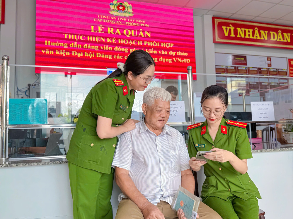 Cán bộ Công an hướng dẫn người dân tham gia đóng góp ý kiến