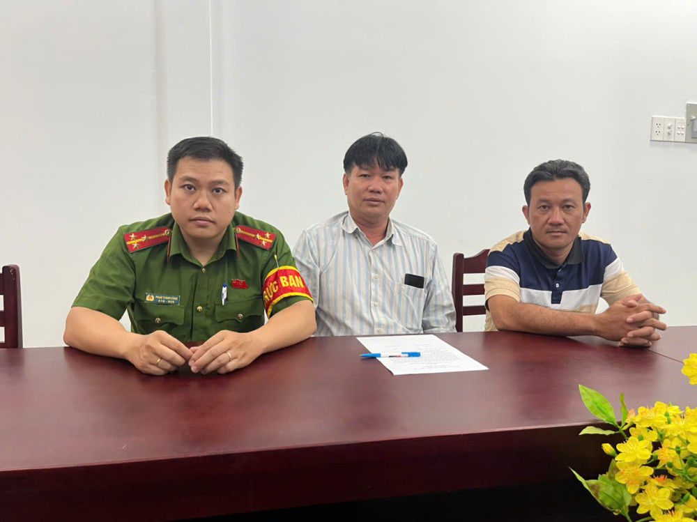 Anh Nguyễn Quốc Huy (giữa) nhận lại số tiền chuyển nhầm từ anh Phan Minh Hoàng (bên phải)