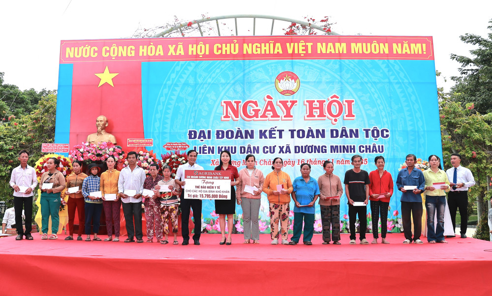 Đại diện Agribank chi nhánh Dương Minh Châu tặng biểu trưng 25 thẻ BHYT cho các hộ gia đình có hoàn cảnh khó khăn