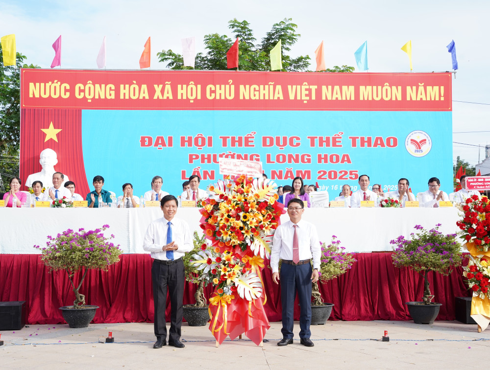 Phó Giám đốc Sở Văn hóa, Thể thao và Du lịch Lê Quang Chánh (bên trái) tặng hoa chúc mừng Đại hội Thể dục thể thao phường Long Hoa lần thứ I năm 2025