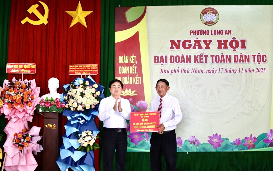 Bí thư Tỉnh ủy Nguyễn Văn Quyết (bên trái) trao biểu trưng tặng 1 căn nhà Đại đoàn kết trị giá 80 triệu đồng cho địa phương