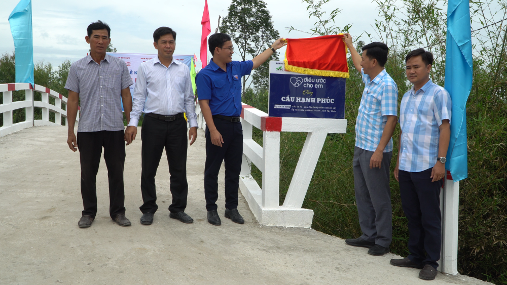 Đại biểu khai bảng tên cầu Hạnh Phúc tại ấp Tân Hiệp, xã Bình Thành