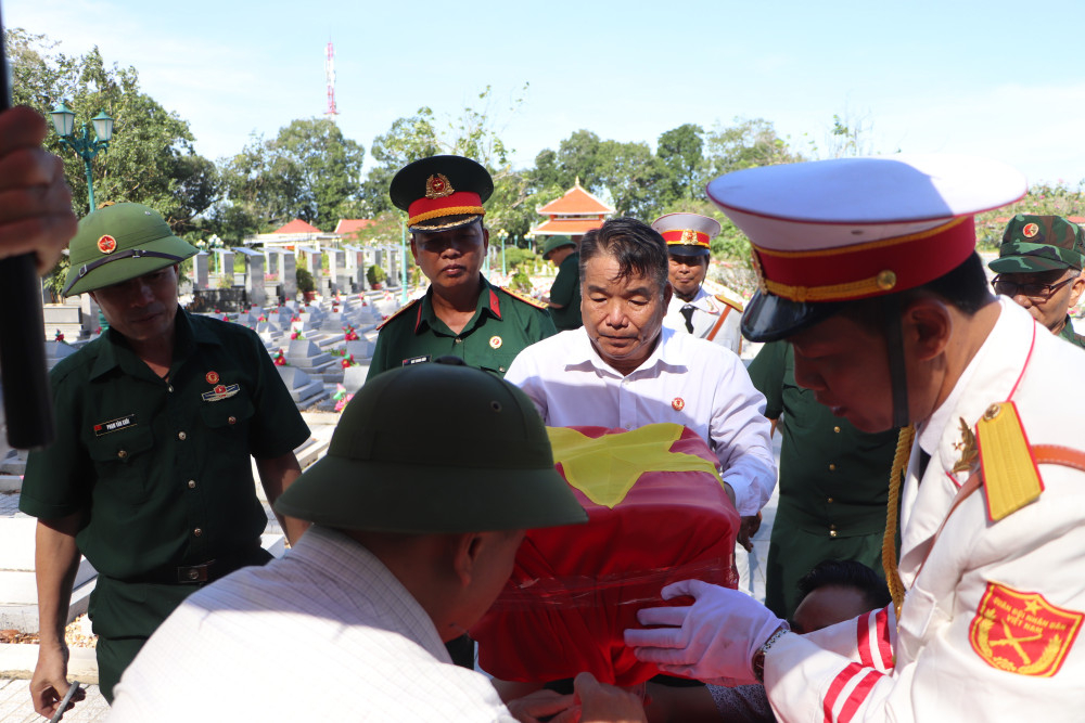 Các đơn vị chức năng và người thân của hai liệt sĩ thực hiện thủ tục cất bốc hài cốt