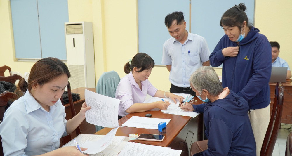 Viên chức Chi nhánh Trung tâm Phát triển quỹ đất khu vực Cần Giuộc hướng dẫn người dân thực hiện thủ tục, hồ sơ ký nhận tiền bồi thường