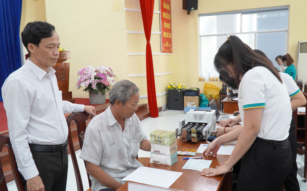 Chủ tịch UBND xã Cần Giuộc Nguyễn Ngọc Anh (bìa trái) đến dự buổi chi trả tiền cho các hộ dân bị ảnh hưởng bởi dự án Khu đô thị thị trấn Cần Giuộc – phía Bắc