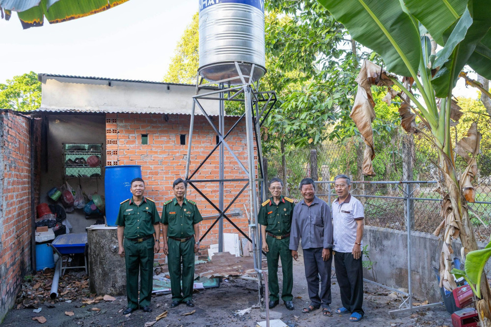 Ông Nguyễn Văn Biển (thứ 2 từ phải sang) nhận hỗ trợ bồn nước sinh hoạt từ Hội Hỗ trợ gia đình liệt sĩ tỉnh Tây Ninh