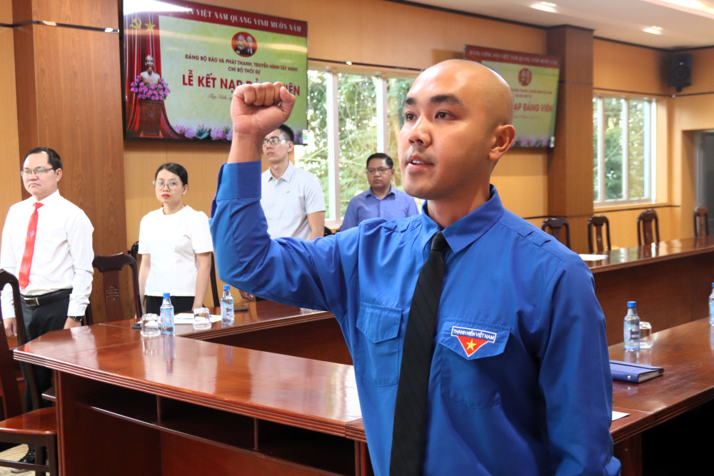 Đảng viên Nguyễn Trường Hải tuyên thệ trước cờ Tổ quốc, cờ Đảng và chân dung Chủ tịch Hồ Chí Minh