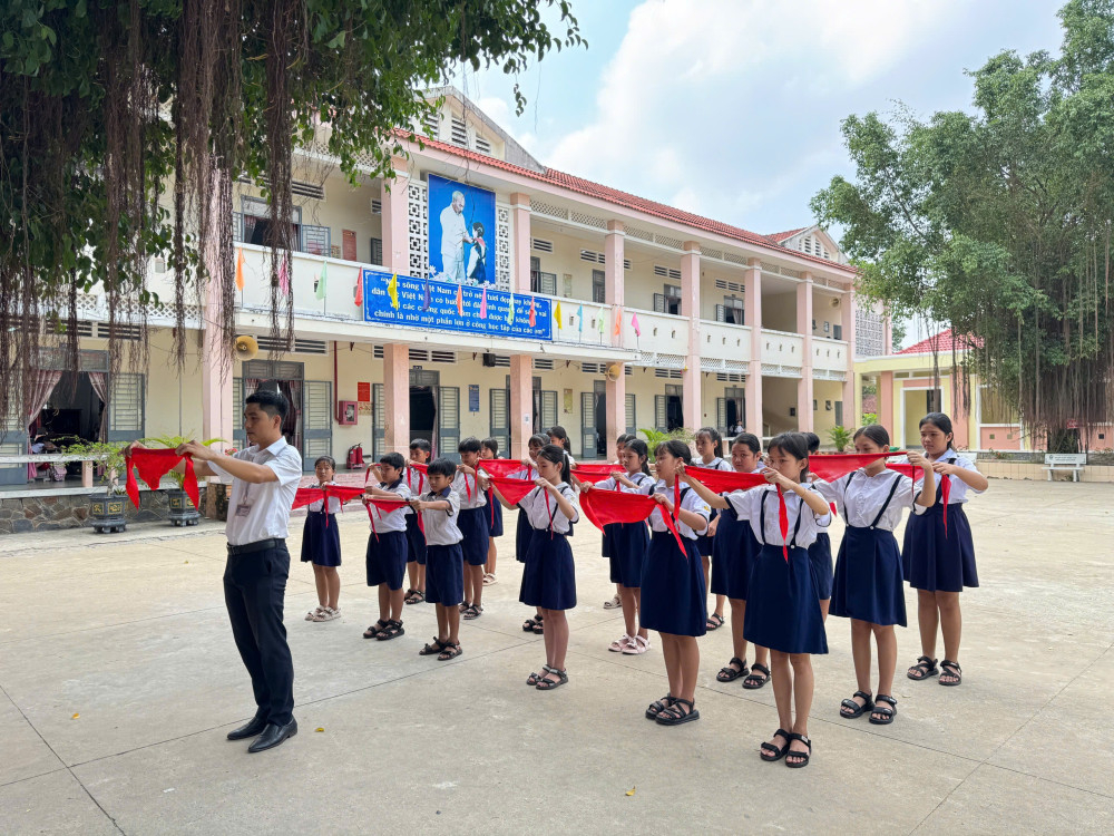 Thầy Nguyễn Việt Phương (Trường Tiểu học Ấp 5 Bàu Đồn, xã Truông Mít) hướng dẫn học sinh thắt khăn quàng đỏ