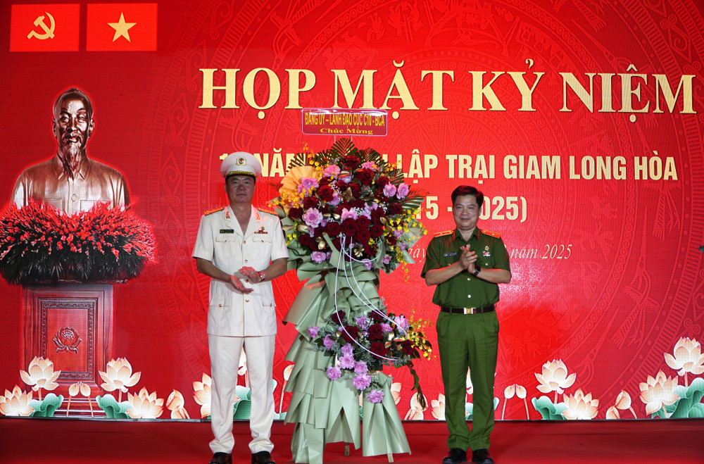 Thiếu tướng Nguyễn Thanh Trường - Ủy viên Đảng ủy Công an Trung ương, Bí thư Đảng ủy, Cục trưởng Cục C10, Bộ Công an (bên phải) tặng lẵng hoa chúc mừng họp mặt