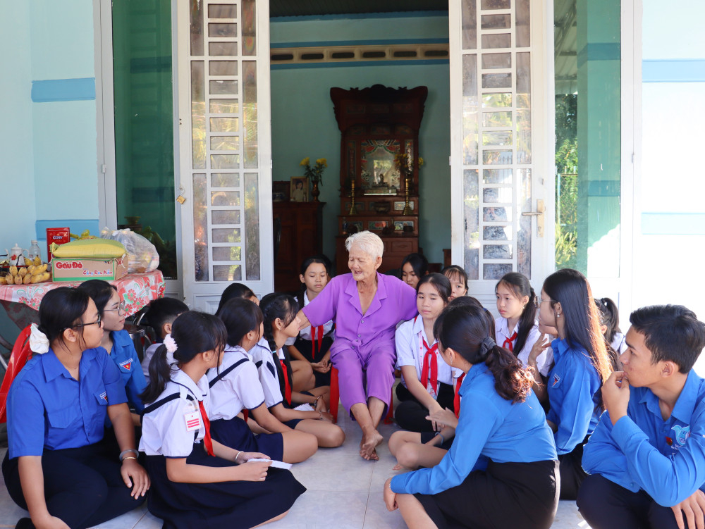 Đoàn viên, thanh niên, các em thiếu nhi phường Bình Minh quây quần nghe cụ Lan kể chuyện kháng chiến