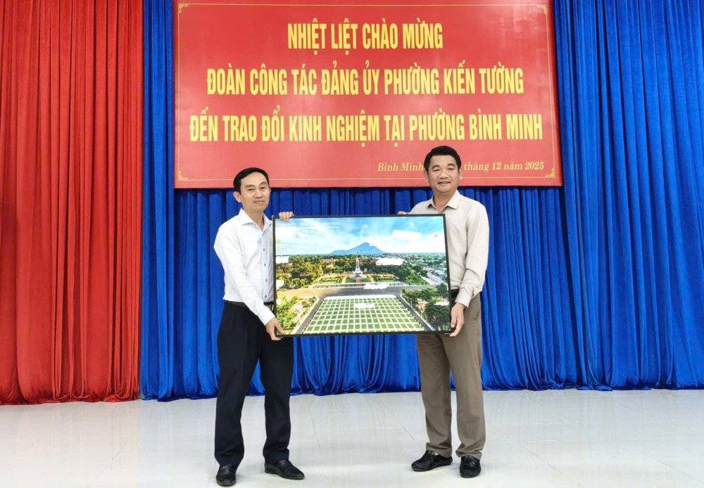 Chủ tịch UBND phường Bình Minh Lương Bá Can (bên trái) trao quà lưu niệm cho lãnh đạo phường Kiến Tường