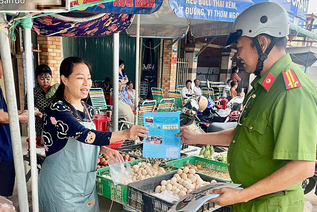 Công an xã phát tờ rơi cho người dân