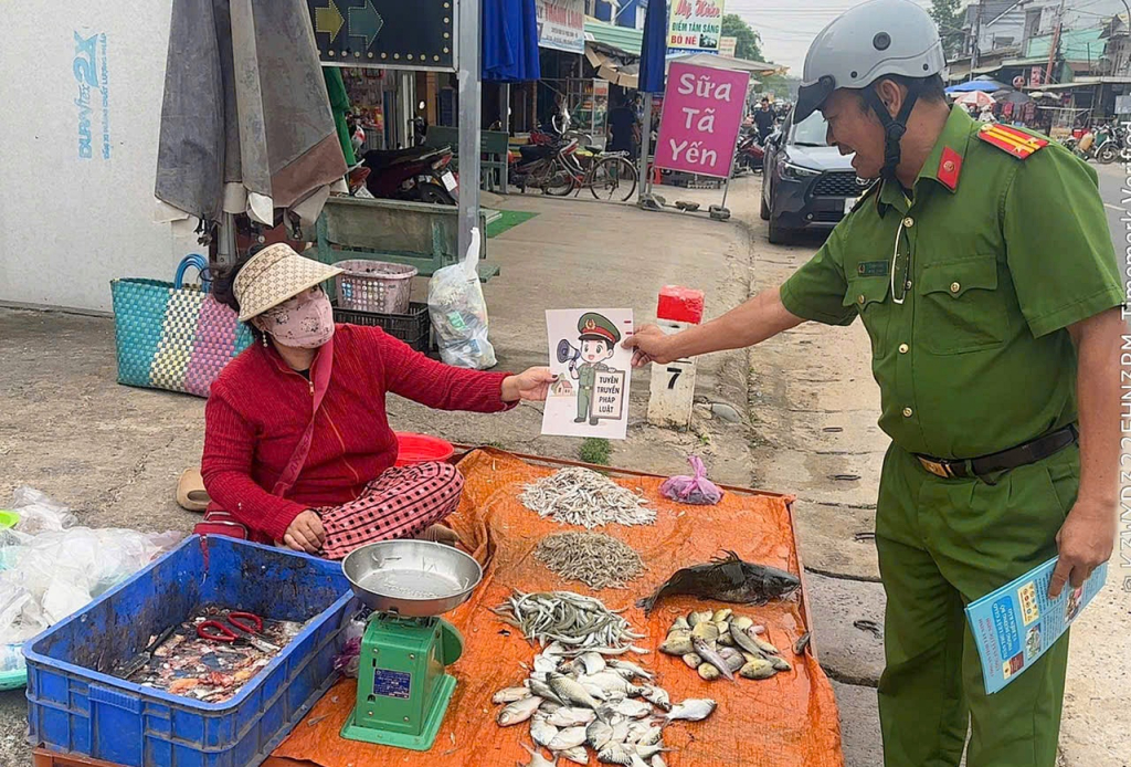 Công an xã phát tờ rơi tuyên truyền cho người dân