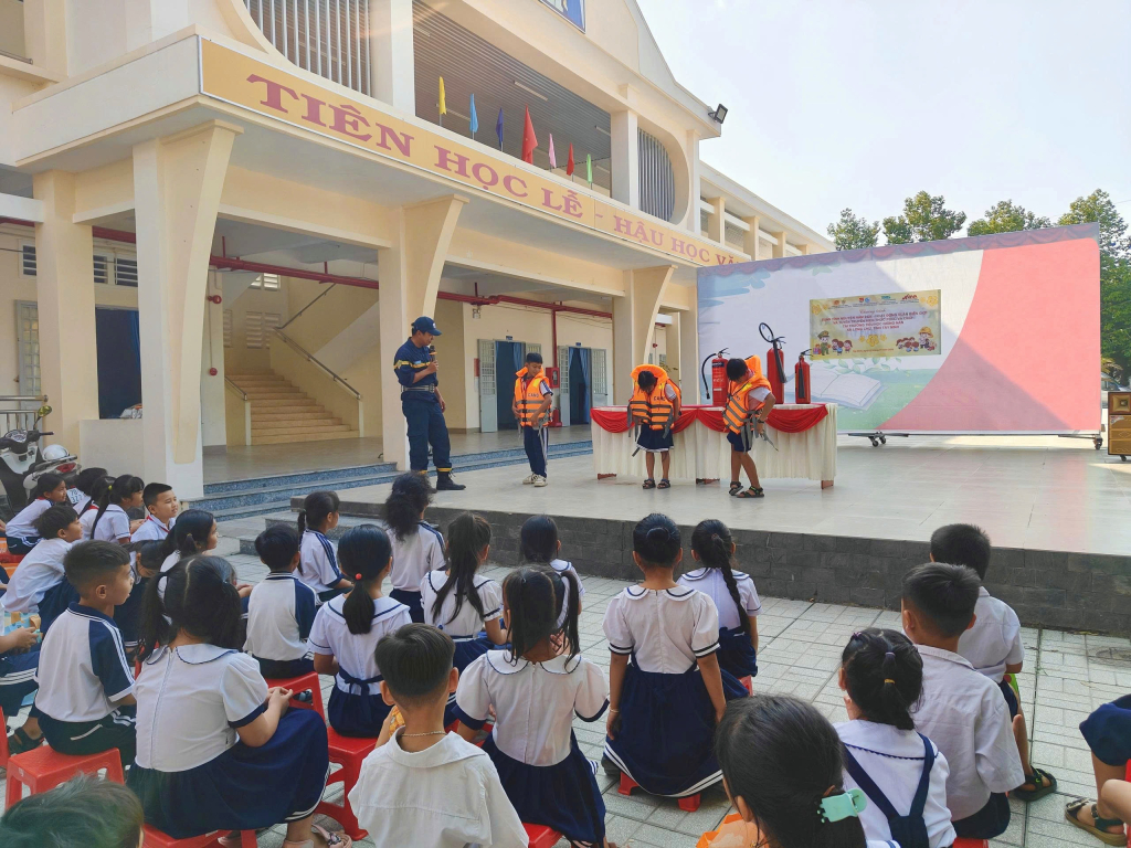 Cán bộ hướng dẫn học sinh mặc áo phao đúng cách