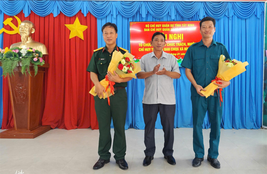 Lãnh đạo xã Bình Thành tặng hoa chúc mừng đồng chí Trần Trường An (bìa phải) và Thiếu tá Trương Viết Vinh (bìa trái)